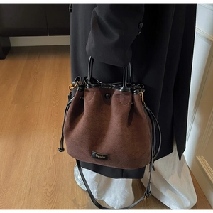 Détails du sac seau en daim marron foncé avec garniture noire et finitions dorées