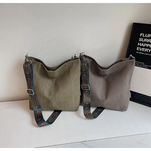 Close-up of canvas bucket bags featuring ethnic print wide shoulder straps and stitching