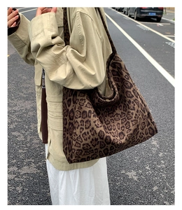 Street style view of the large leopard print tote bag worn as a shoulder bag