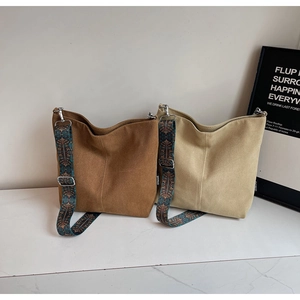 Detail view of coffee and beige tote bags featuring ethnic style wide shoulder straps