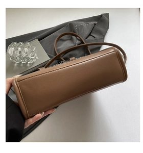 Détails de la base et des coutures fines du sac fourre-tout en cuir marron à bandoulière