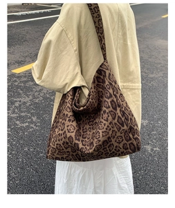 Detail view of large leopard print tote bag showing slouchy texture and casual shoulder fit
