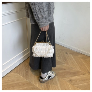 Détail du sac de soirée en dentelle blanche avec poignée perle et chaîne dorée
