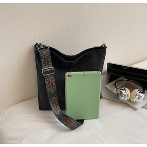 Large black shoulder tote bag with ethnic woven strap showing spacious storage for a tablet