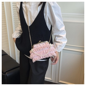 Détail d'un sac à main rose en dentelle à volants avec perles et fermoir métallique doré