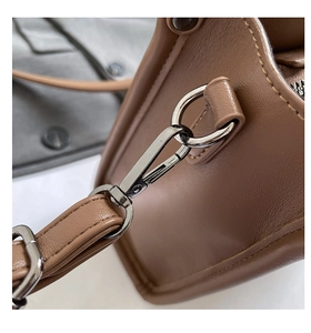 Vue détaillée du cuir marron grainé et du crochet en métal argenté du sac