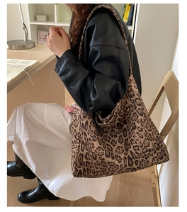 Borsa tote in tela con stampa leopardata indossata da modella in un ufficio moderno
