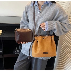 Détail du sac seau en daim avec pochette interne et bandoulière réglable en cuir