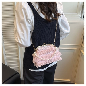 Détail du sac en dentelle rose avec poignée en perles et fermoir en métal vintage de près