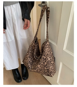 Borsa tote in tela leopardata appesa alla maniglia di una porta in un ambiente reale