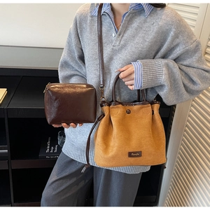 Détail du sac seau en daim avec pochette en cuir et bandoulière réglable pratique