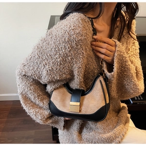 Detalle de bolso hobo con cierre dorado y correa de cadena en ante de color beige