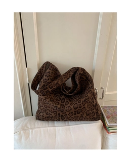 Macro shot of dark leopard print tote bag with thick canvas texture and soft drape detail