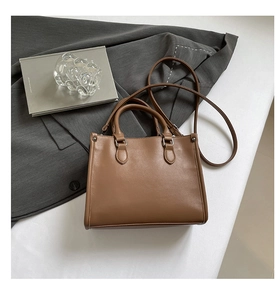 Vue détaillée d'un sac cabas en cuir marron avec poignées sur une veste de costume grise