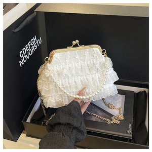 Détail du sac de soirée en dentelle blanche à volants avec anse en perles et fermoir doré