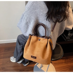 Vue arrière d'un mannequin portant le sac seau en daim marron dans un décor cosy