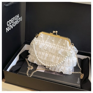 Détail de sac de soirée en dentelle blanche avec chaîne perle et fermoir doré en boîte