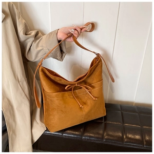 Detail of caramel suede tote bag with bow drawstring and white contrast stitching