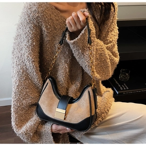 Detalle del bolso de hombro retro de ante beige con ribete de cuero negro y cadena dorada