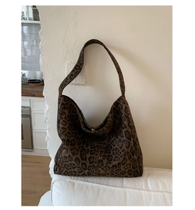 Detailed close-up of the leopard print fabric and thick strap of this large tote bag