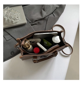 Vue intérieure d'un grand sac marron avec compartiments pour tablette et maquillage
