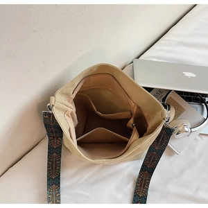 Top view of canvas bucket bag interior featuring multiple compartments and bohemian strap