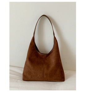Macro view of brown suede hobo tote bag featuring minimalist retro seam details