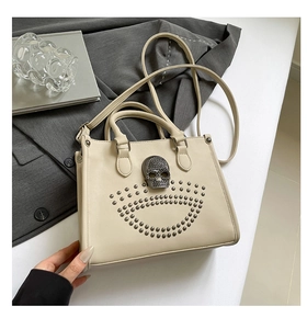 Détail du sac cabas en cuir crème avec tête de mort noire et rivets argentés