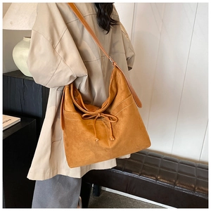 Détail du sac cabas marron avec surpiqûres contrastées et nœud sur l'épaule