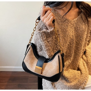 Detail of vintage patchwork shoulder bag with gold chain strap and metallic buckle