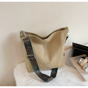 Detail of khaki canvas bucket bag featuring ethnic patterned wide shoulder strap