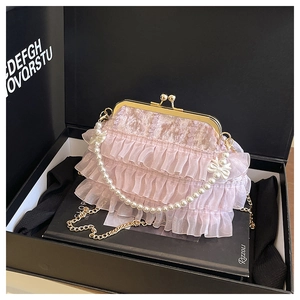 Détail du sac à main rose en dentelle avec poignée perle et chaîne dorée en coffret
