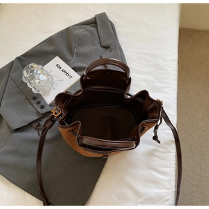 Vue de dessus du sac seau en daim montrant le cordon et les détails en cuir marron