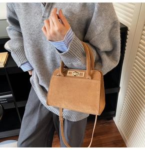 Brown suede leather tote bag worn as a shoulder bag by a model in a modern room