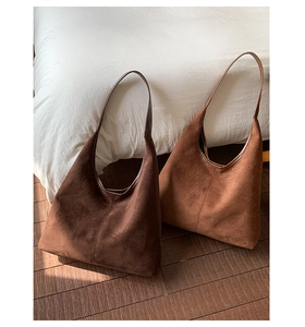 Detailed close-up of minimalist hobo tote bags in brown and coffee suede leather