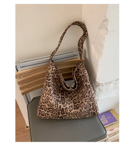 Detailed close-up of leopard print tote bag with soft faux suede texture on a chair