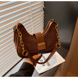 Detail of hobo shoulder bag with matte leather stitching and a thick gold chain strap