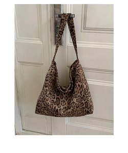 Close-up of leopard print tote bag with wide shoulder strap and metal snap button closure