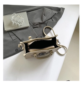 Vue de dessus d'un cabas beige montrant la doublure noire et la pochette intérieure zippée