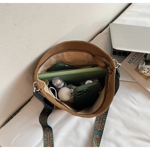 Top view of spacious canvas bucket bag interior showing wide ethnic print strap and capacity