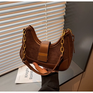 Detail of vintage brown shoulder bag with suede patchwork and gold chain strap