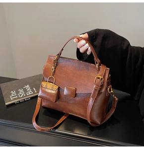 Detail of vintage brown leather handbag with mini coin purse and bronze hardware