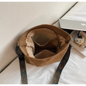 Detail of canvas bucket bag interior with zipper pocket and patterned strap