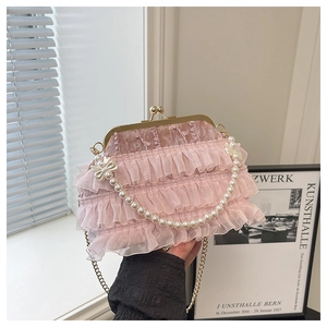 Détail du sac en velours rose avec volants en organza, poignée en perles et fermoir doré