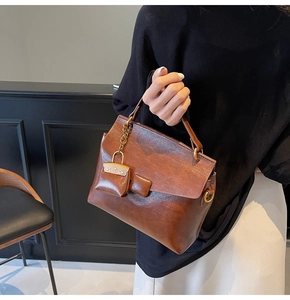 Retro brown oil wax leather square handbag featuring a mini decorative charm and gold chain
