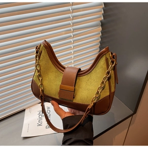 Close-up of green suede and brown leather half-moon bag with gold metal buckle