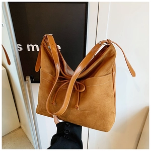 Gros plan détaillé d'un sac cabas en daim marron avec nœud décoratif et coutures