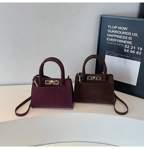 Detailed shot of retro suede handbags with decorative gold locks and adjustable straps