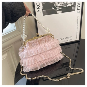 Détails du tissu en velours rose, des volants en organza et de l'anse en perles