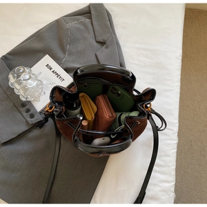 Vue intérieure d'un sac seau en daim marron montrant le rangement du téléphone et du portefeuille